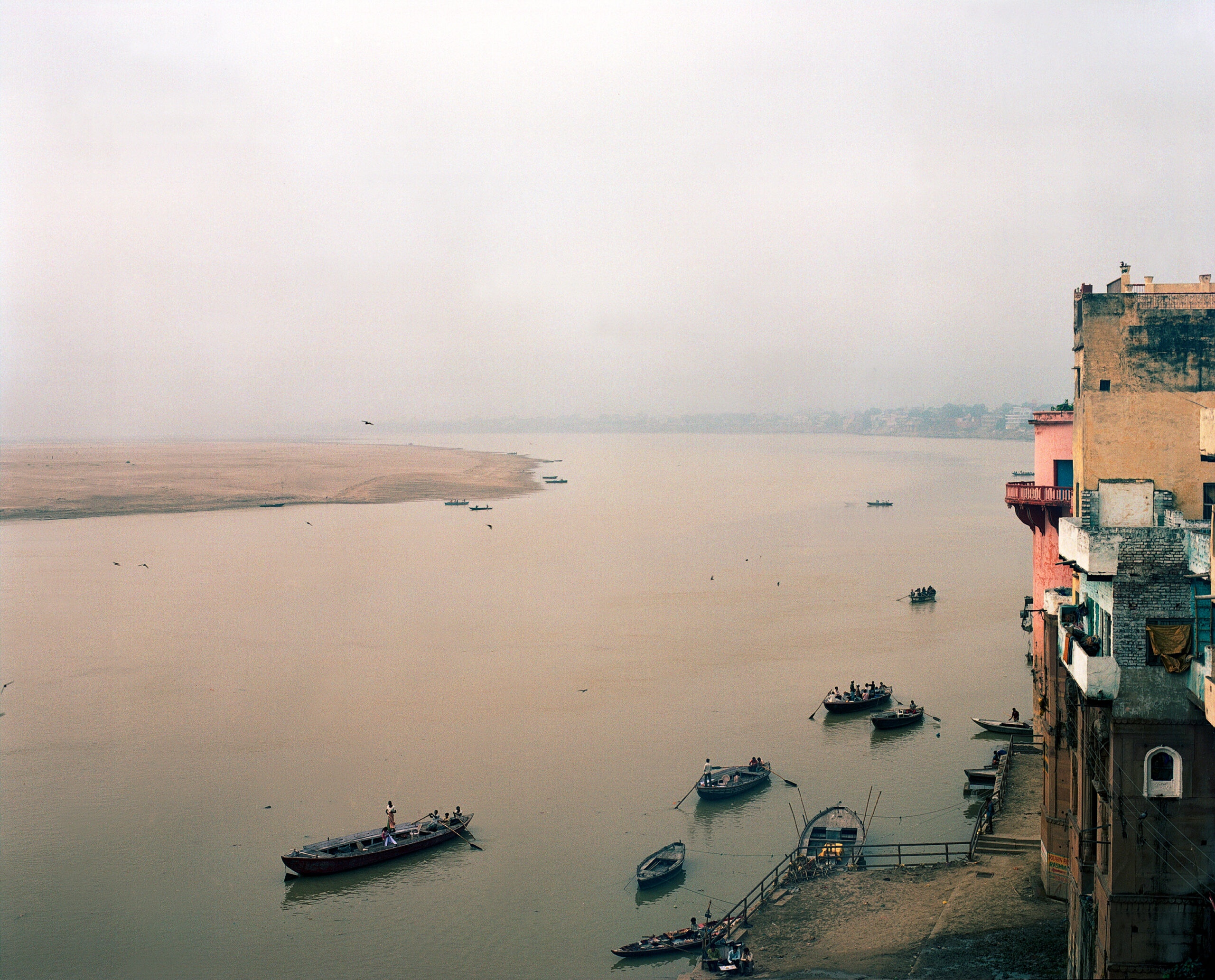 Stimmungsvoller Sonnenaufgang am Ganges in Varanasi – Boote, Licht und Spiritualität im ersten Licht des Tages Wärend einer Fotoreise in Indien: Sonnenaufgang über dem Ganges in Varanasi – sanftes Morgenlicht taucht den Fluss in pastellige Töne. Boote gleiten lautlos durchs Wasser, Rauch von Räucherwerk steigt auf. Die Szene strahlt Ruhe, Spiritualität und den Zauber eines neuen Tages an einem der heiligsten Orte Indiens aus.